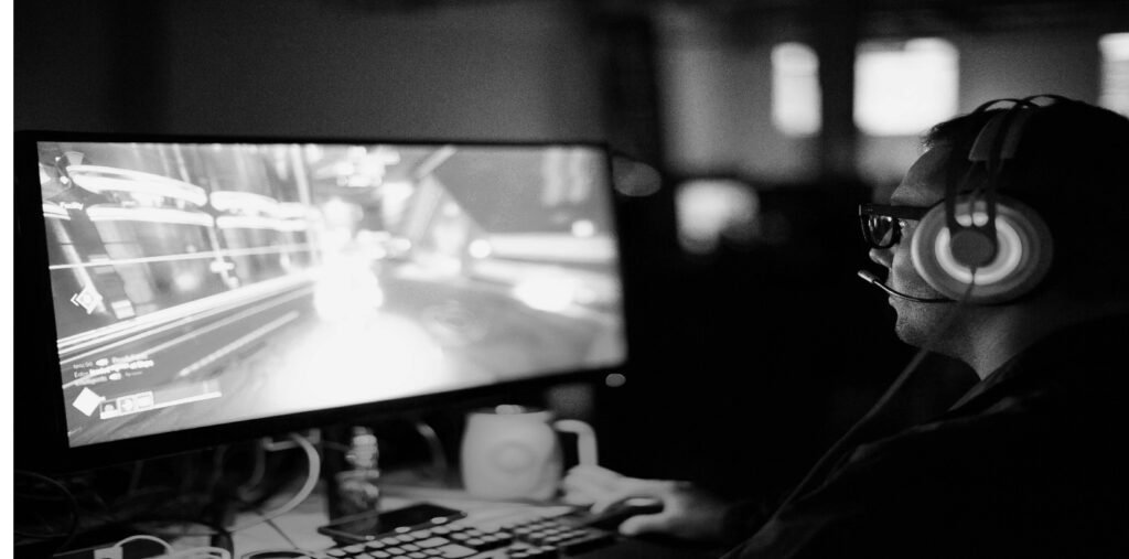 Gamer in a headset playing on a computer screen